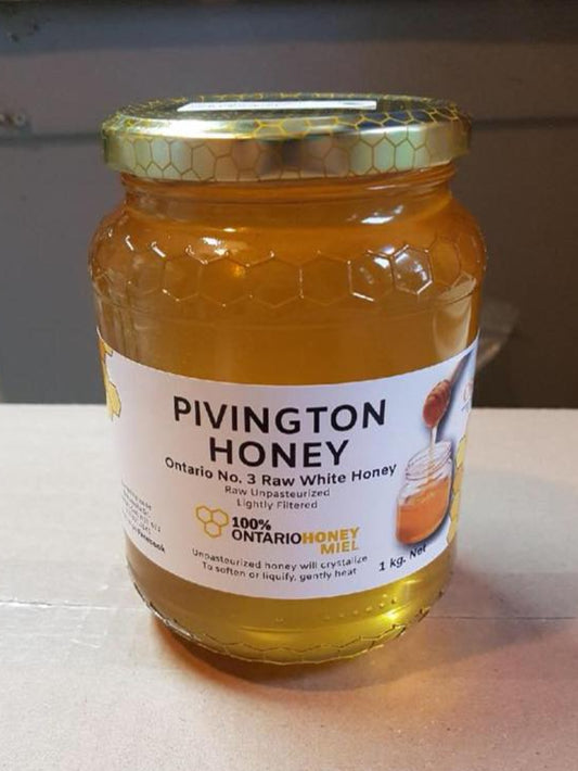 Jar of Pivington Honey on a light surface with a neutral background